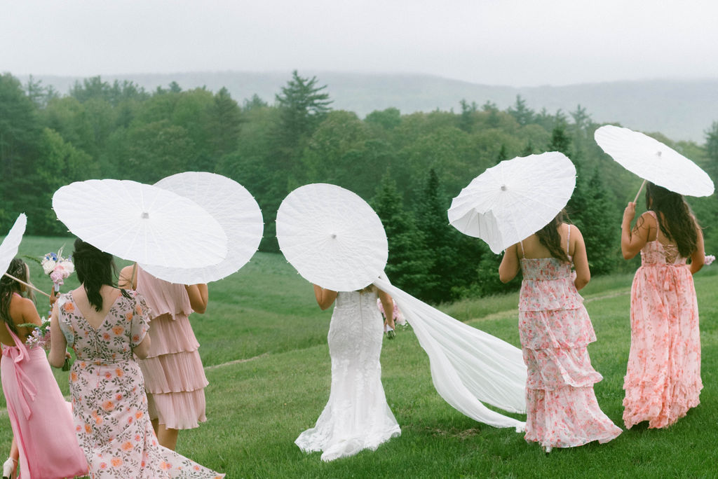 bride & bridesmaids walking with parasols 