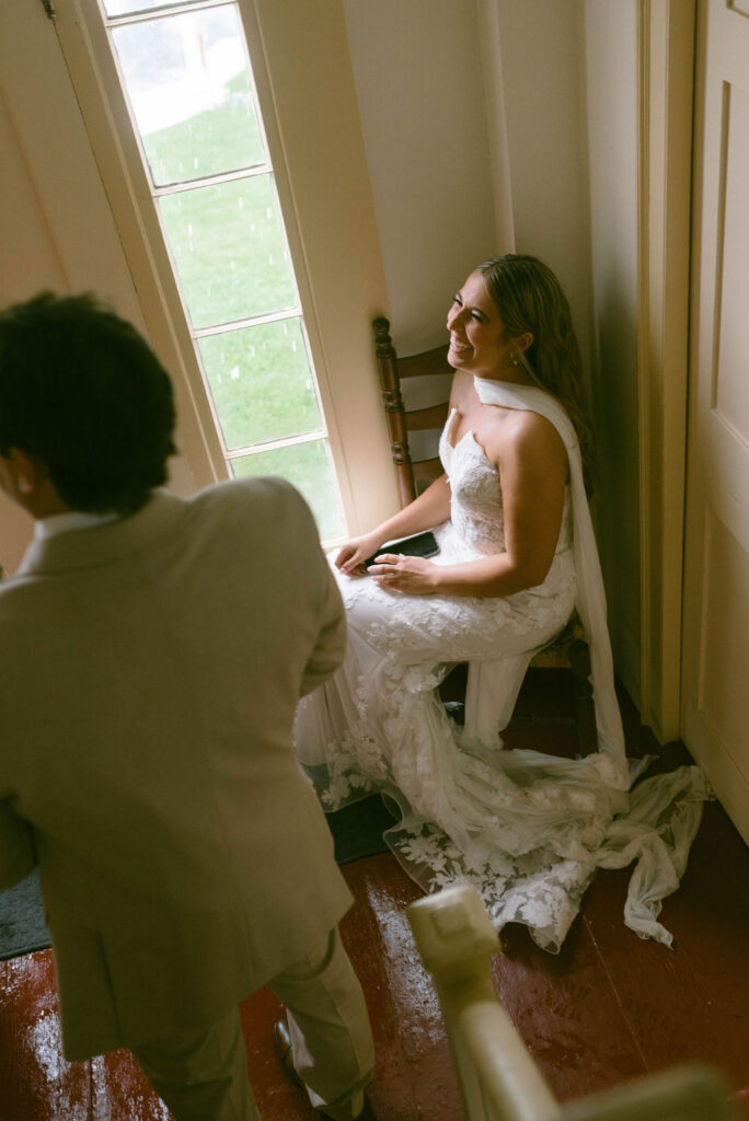 bride looking out the window waiting for the rain to pass 