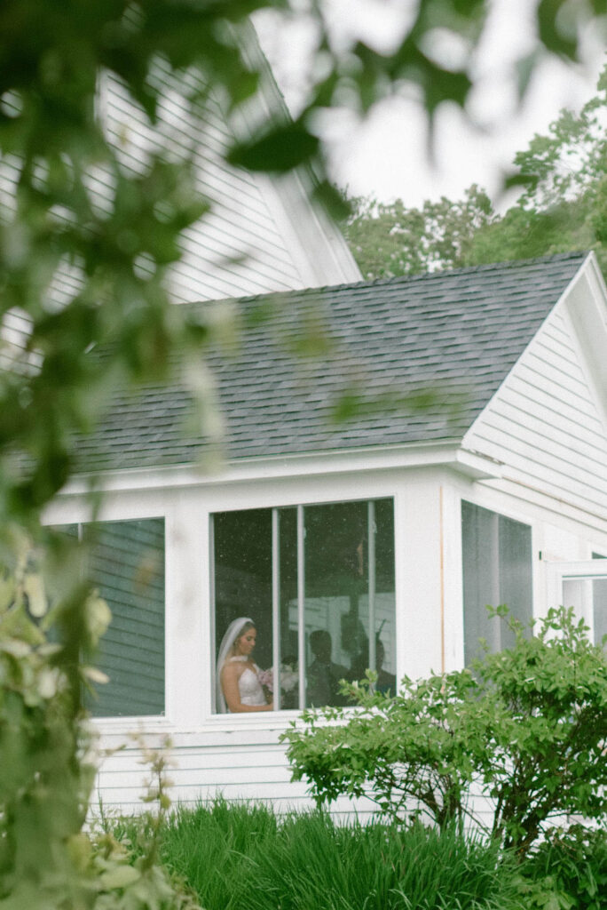 Bride looking out window waiting to walk down the aisle 