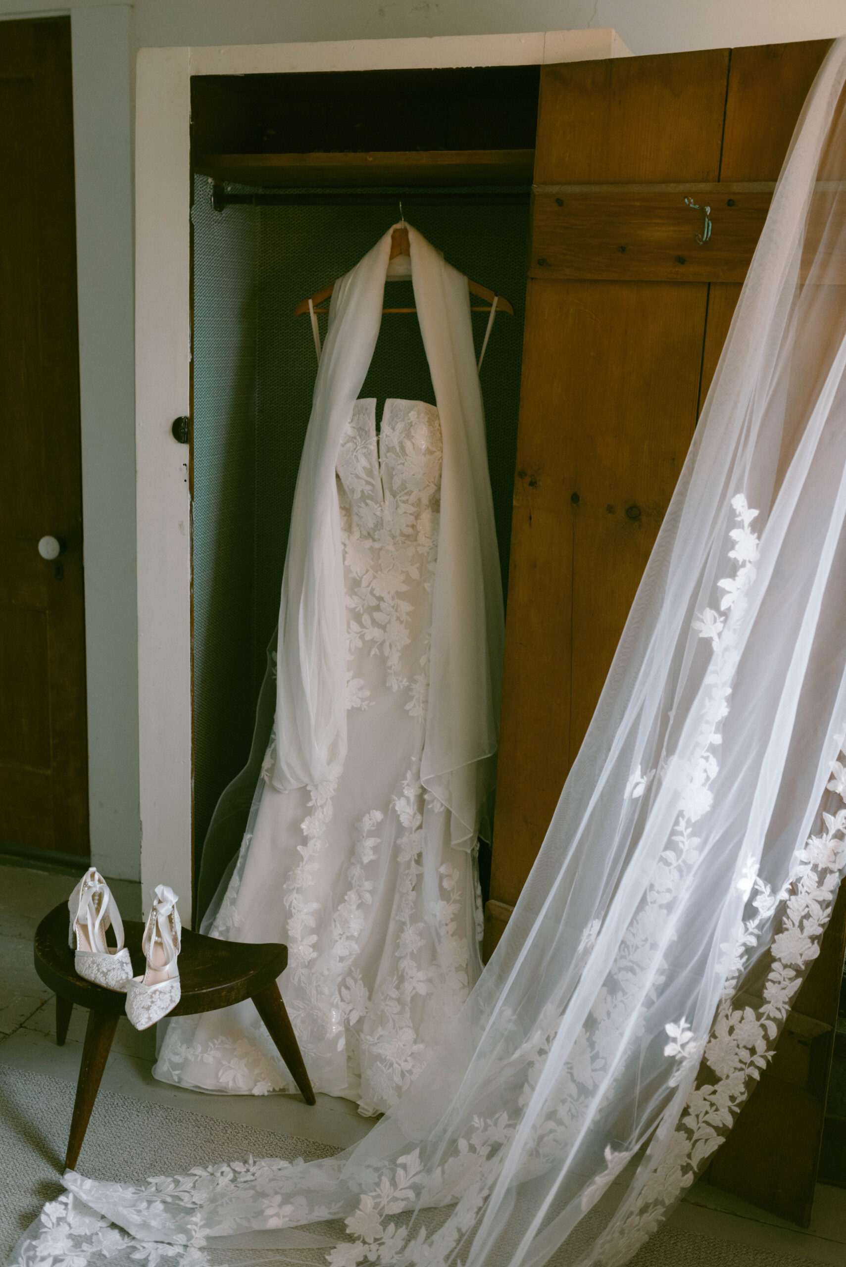 Bridal details dress and veil hanging in an antique wardrobe Saddle Hill Farm wedding
