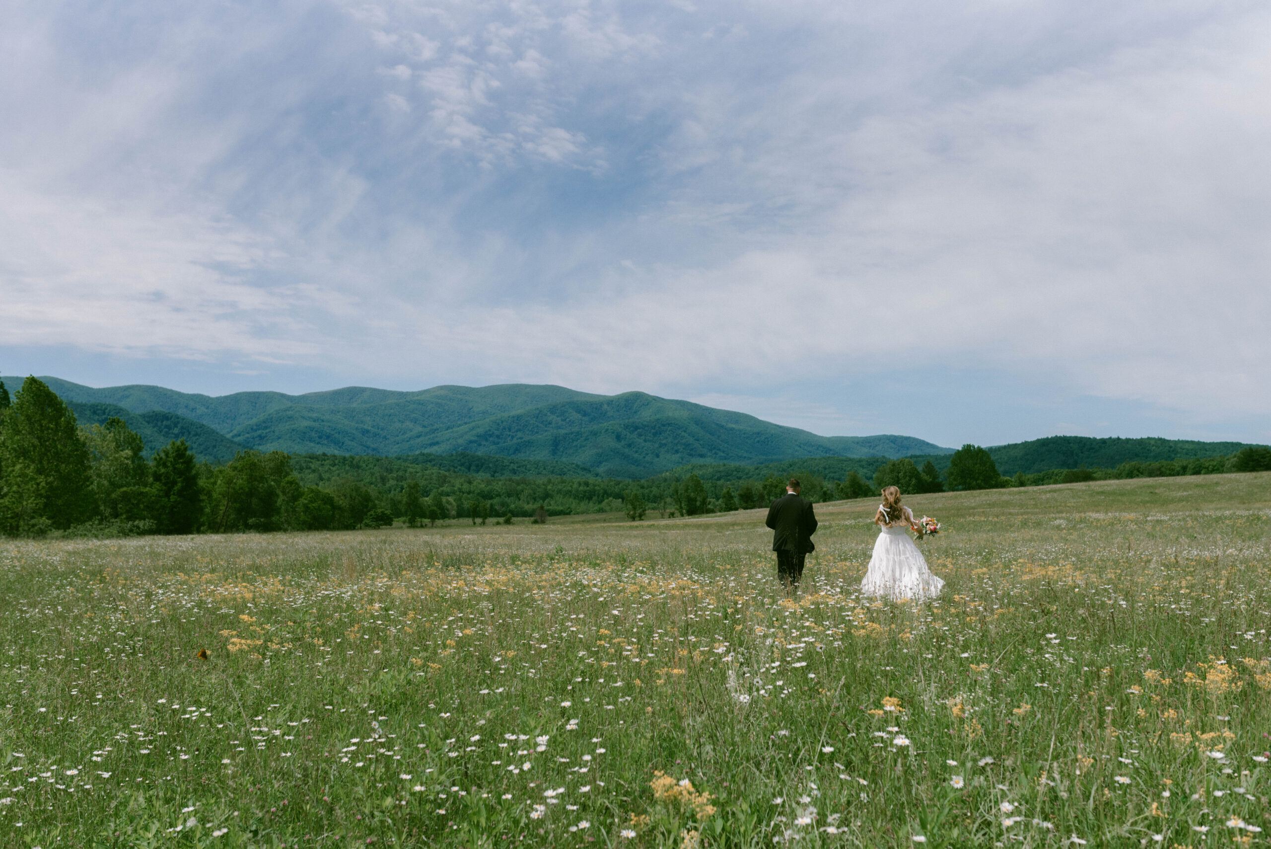 Your Dream Guide to a Smoky Mountain Elopement Bride & Groom in a field of wildflowers