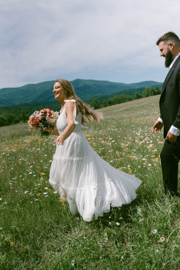 Your Dream Guide to a Smoky Mountain Elopement Bride & Groom in a field of wildflowers