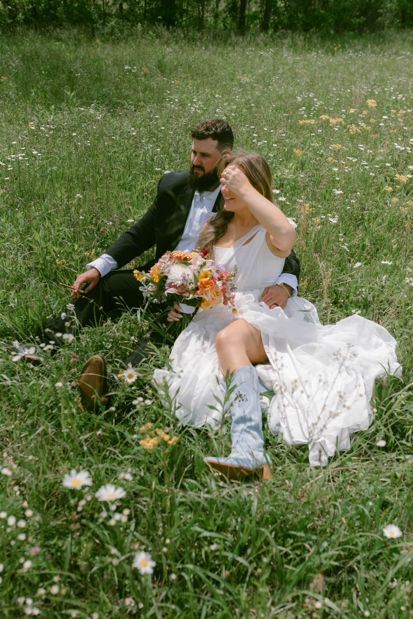 Your Dream Guide to a Smoky Mountain Elopement Bride & Groom in a field of wildflowers blue cowgirl boots