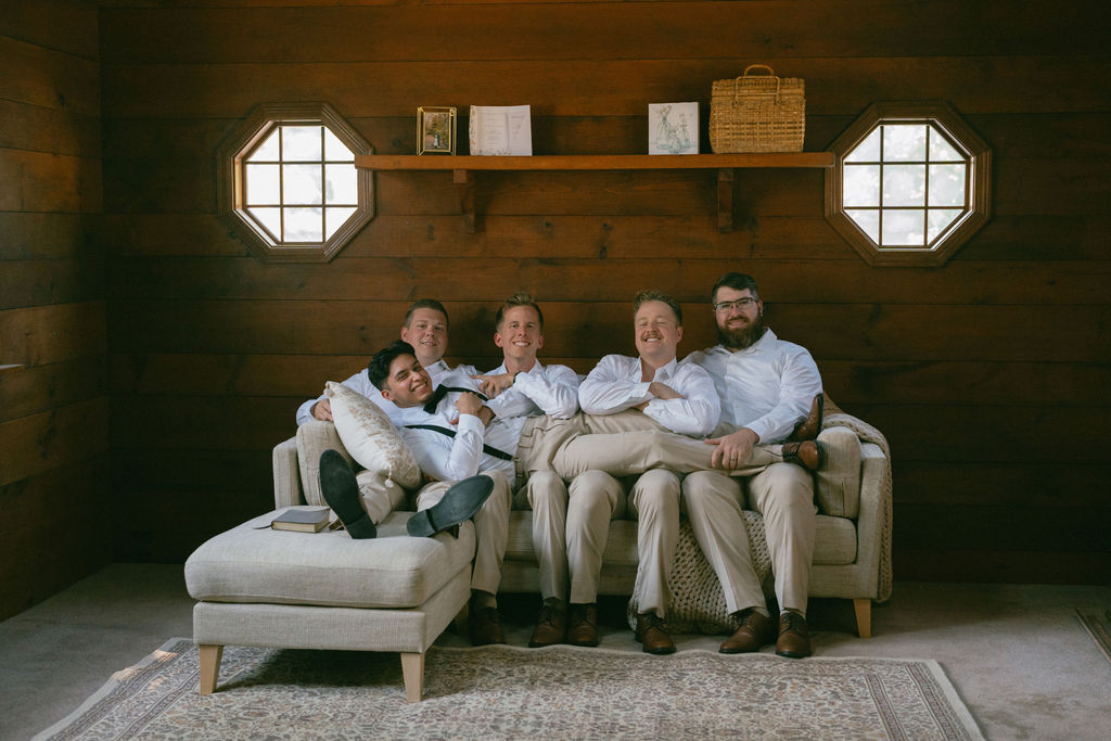 Groom and his groomsmen seating on a sofa before the ceremony