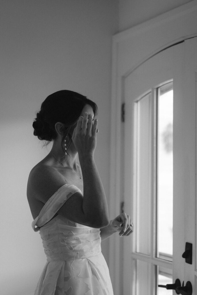 b&w photo of the bride touching her face