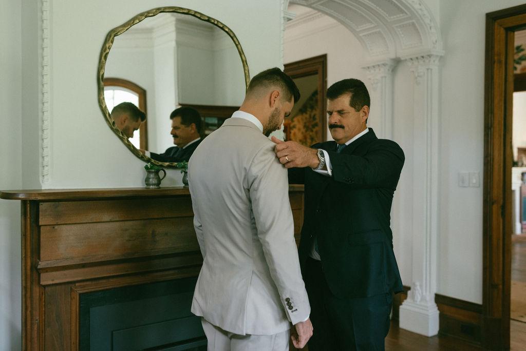 father of the groom helping him get ready