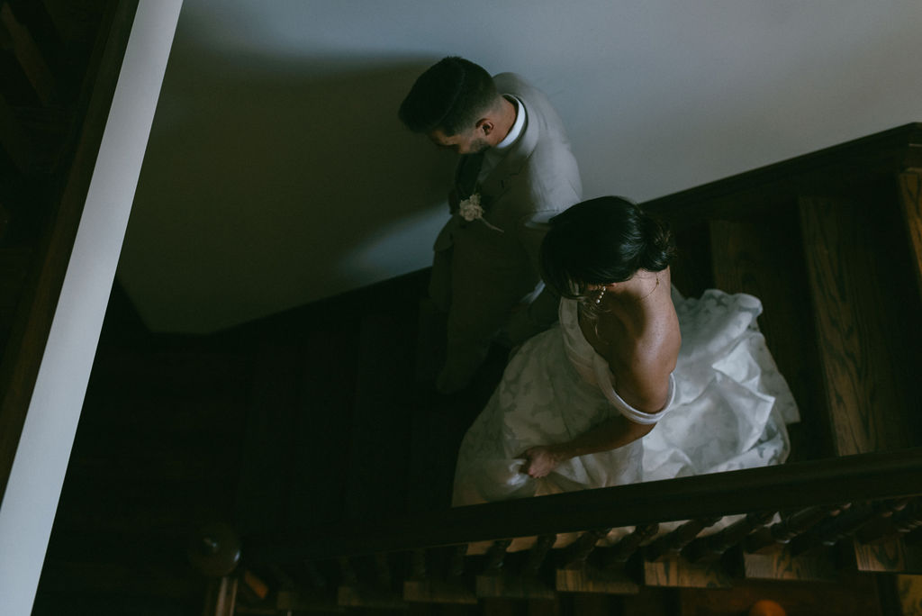 bride and groom holding hands walking down the stairs