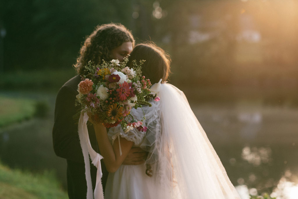 couple kissing with the sun in the background at their intimate wedding day