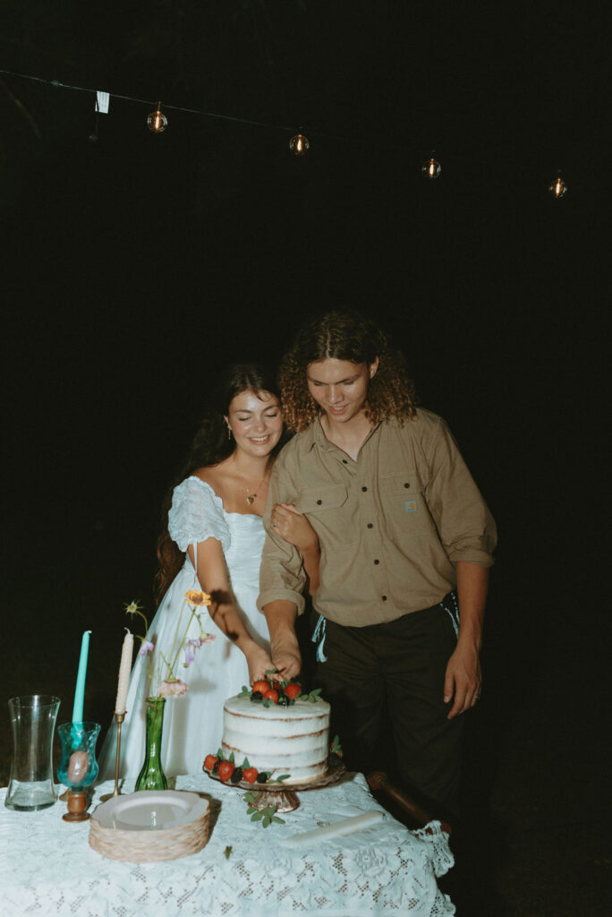 stunning couple cutting their wedding cake 