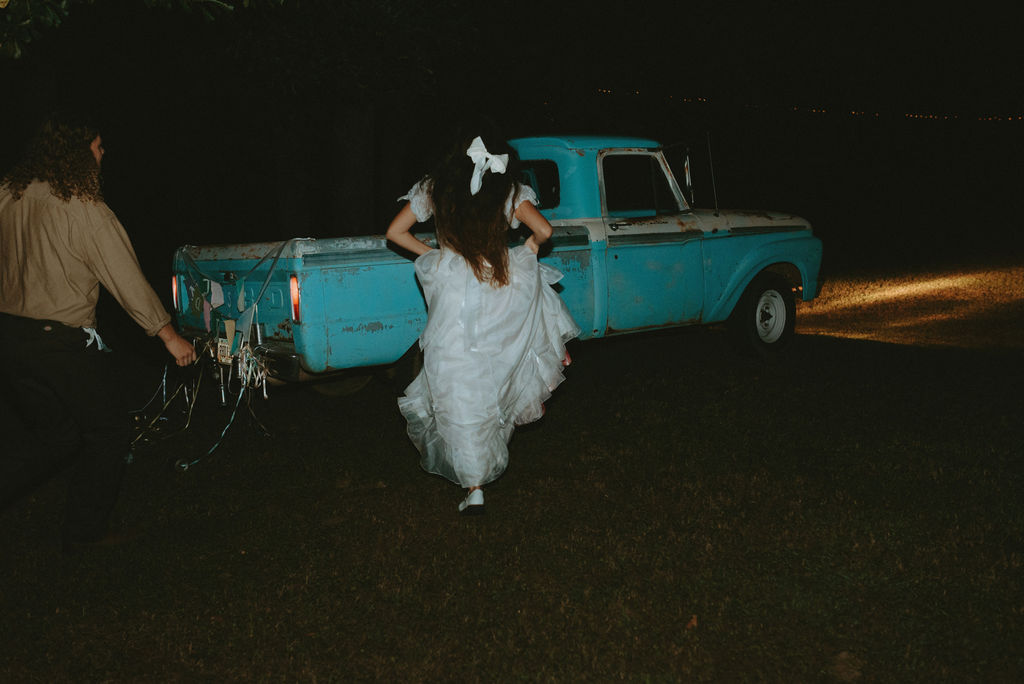 couple running towards the vintage truck they left after their reception