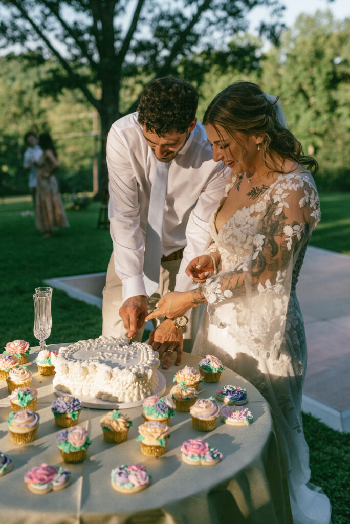 beautiful couple cutting their wedding cake