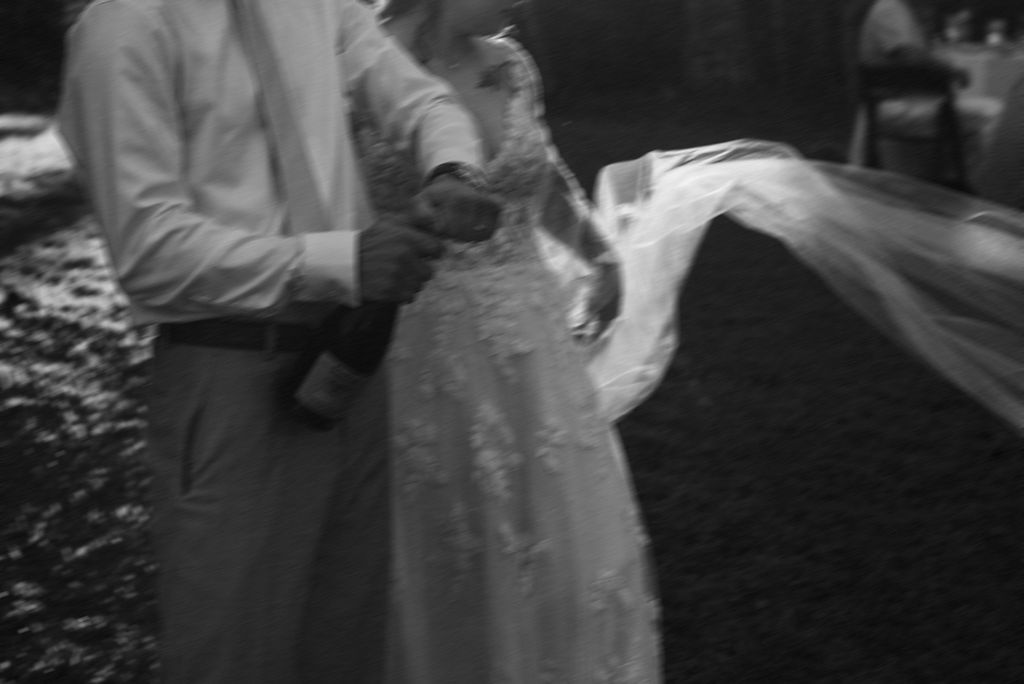 couple opening a bottle of champagne at their intimate backyard wedding 