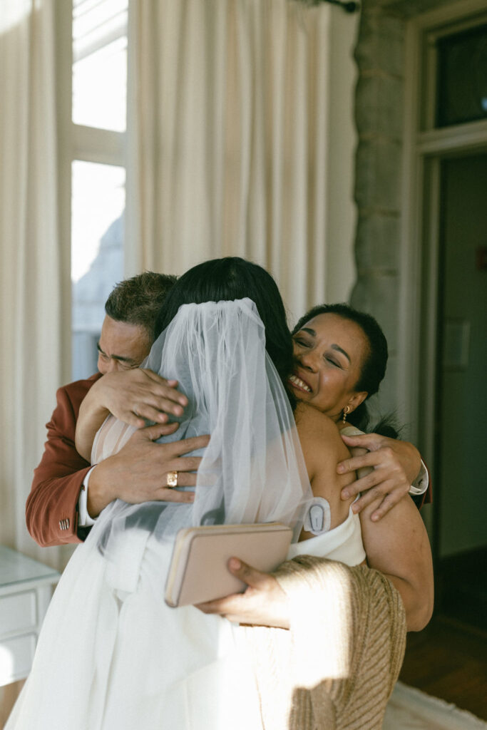 bride and her parents hugging