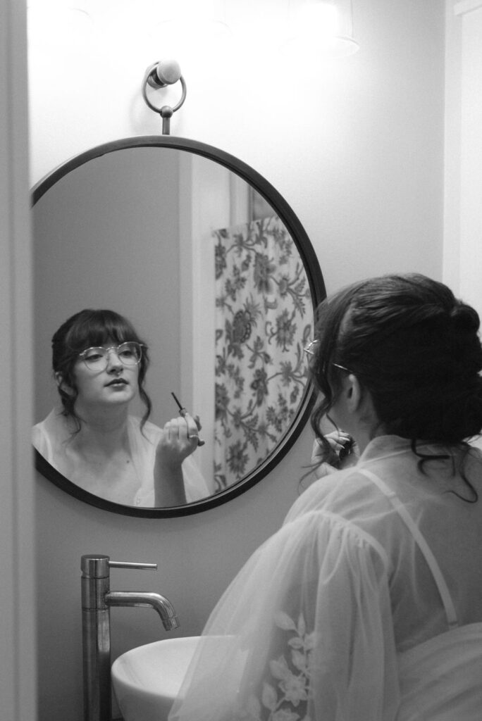 bride doing her makeup for her ethereal wedding day ceremony 