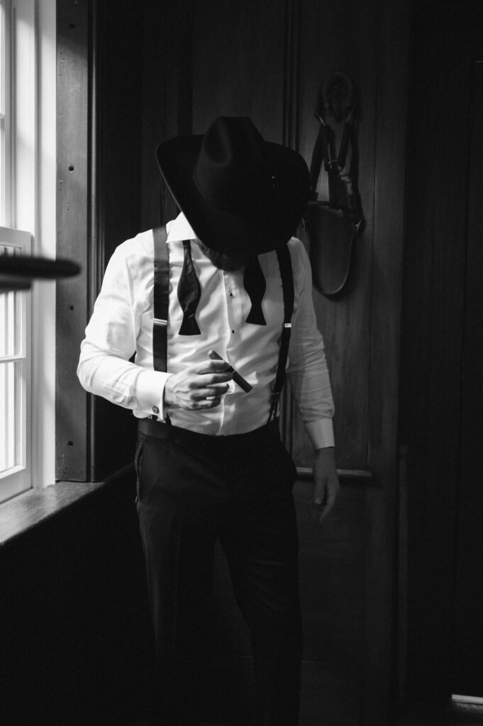 Groom in Cowboy hat with cigar in tack room