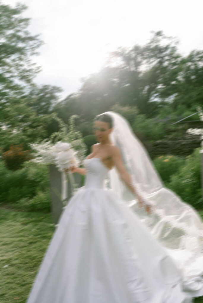 Blurry and elegant photo of the bride with veil flowing