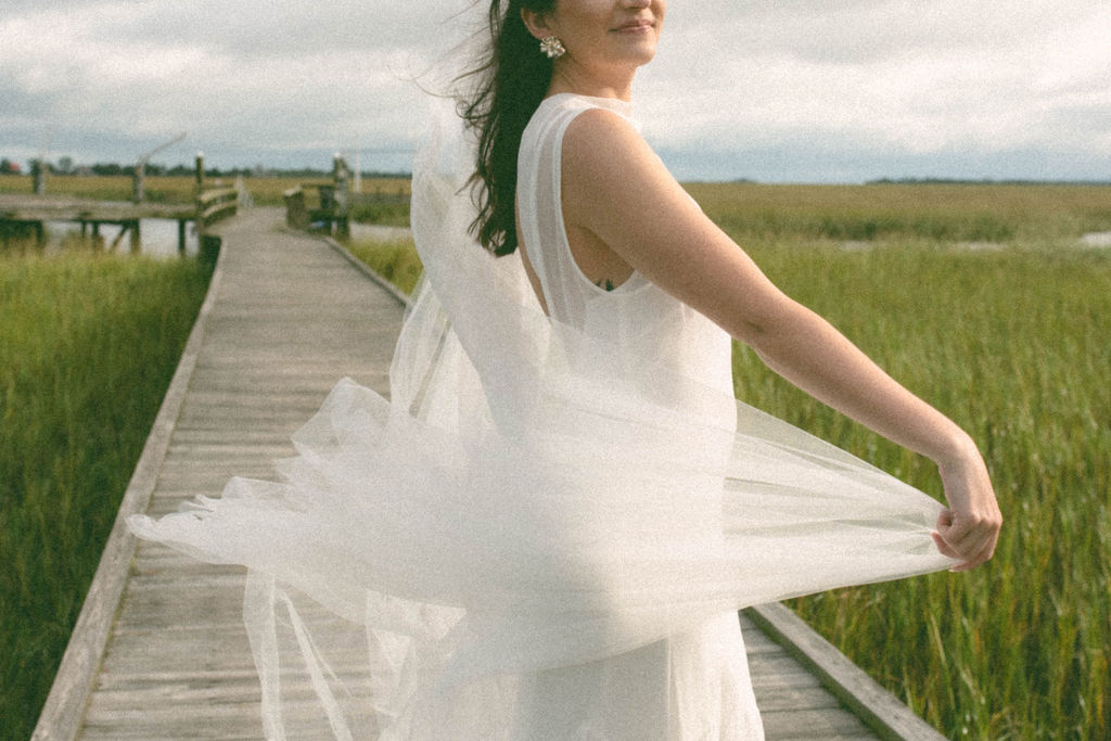 Bride with veil flowing in the wind at the venue on tybee