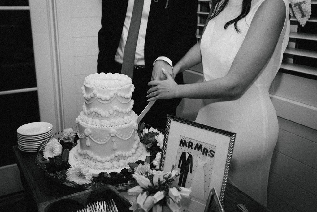 bride & groom cutting cake in black and white