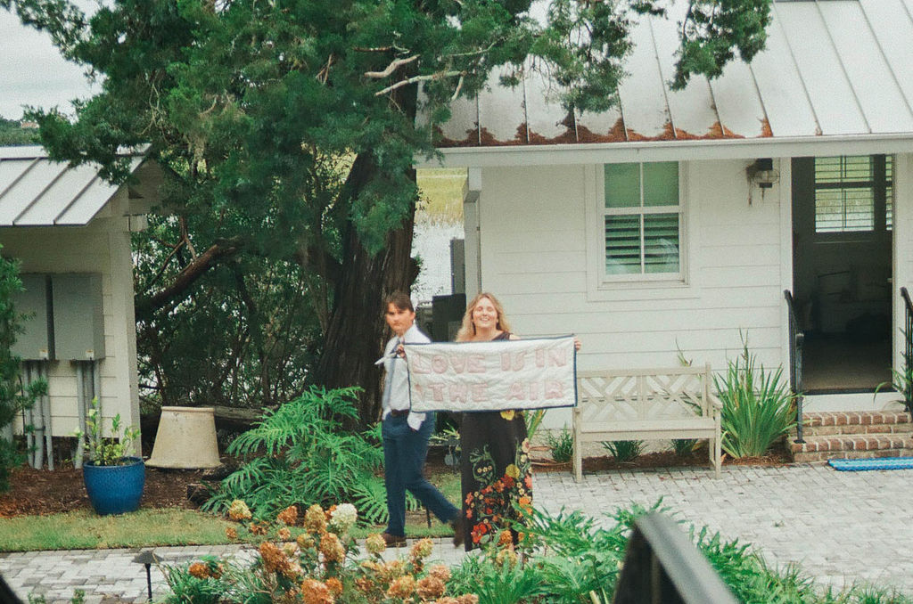 friends holding hand sewn love is in the air sign on 35 mm film
