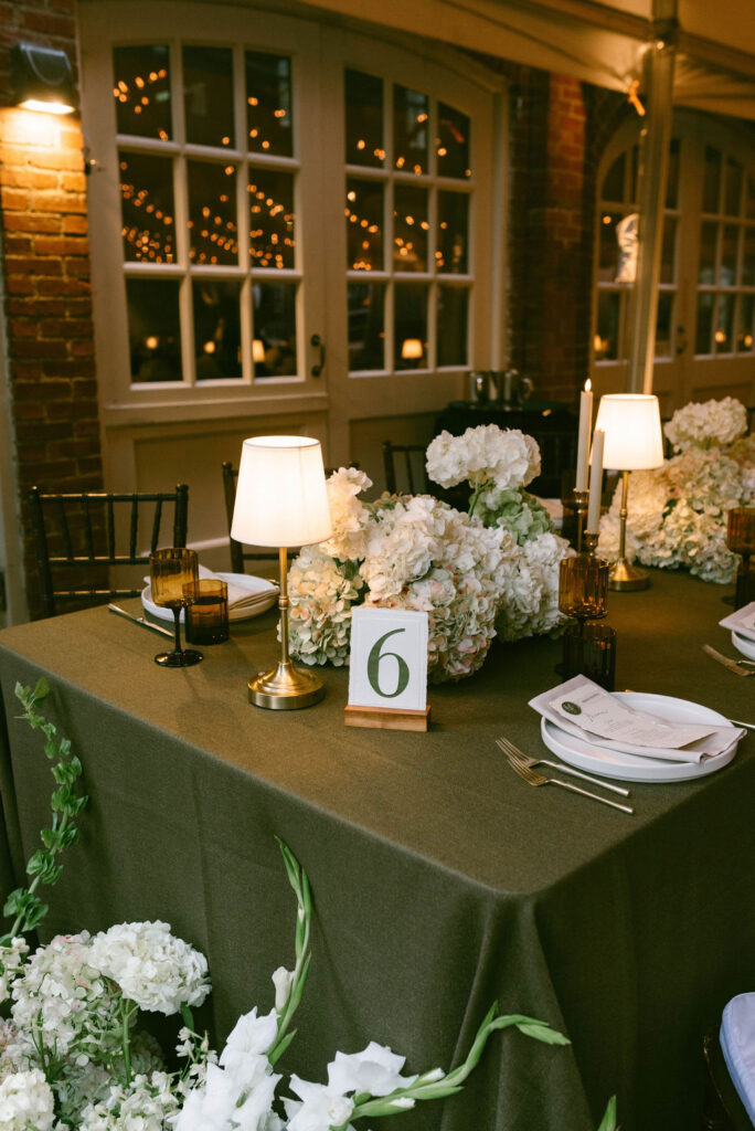 Reception at Cheekwood Estate String Lights with olive green tablecloths and hydrangeas on the tables
