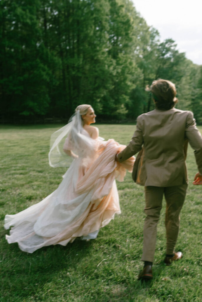 Bride and groom celebrating in field after wedding