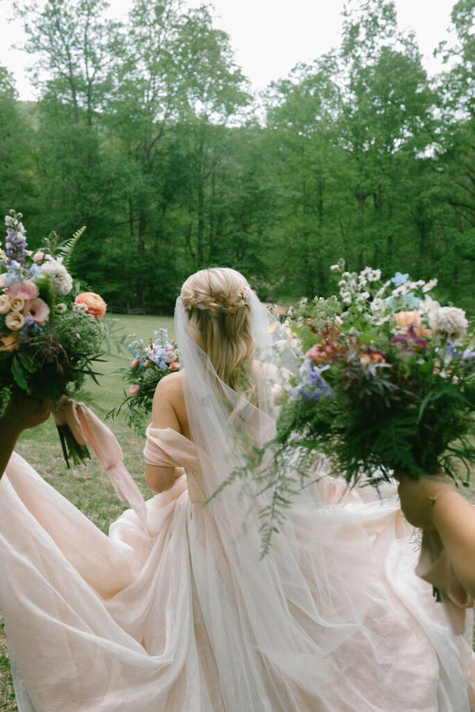 bride and bridesmaids walking with florals