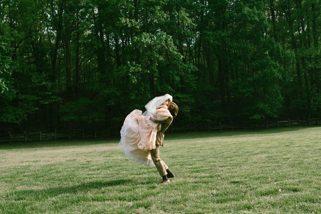 Bride and groom celebrating in field after wedding fairytale bride