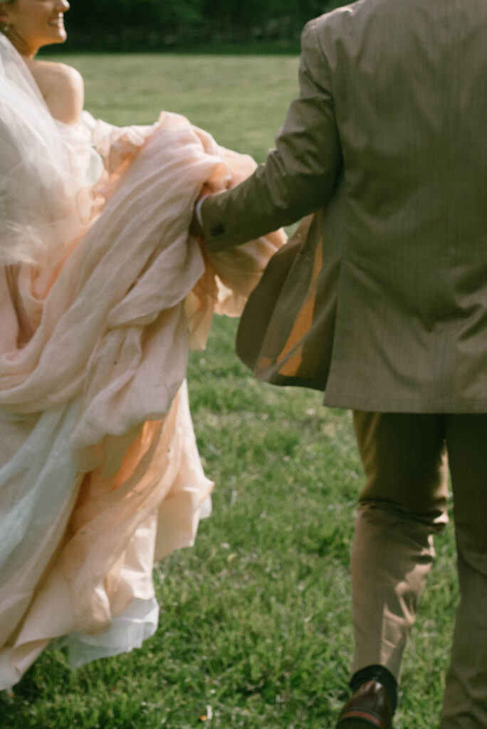 Bride and groom celebrating in field after wedding