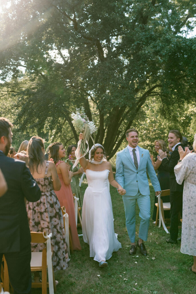 bride & groom walking don the aisle at a jane austen inspired intimate backyard wedding