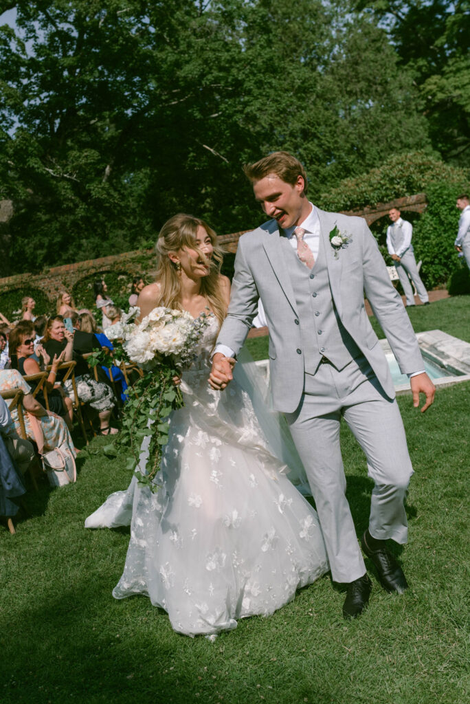 A Romantic Connecticut garden wedding first look down the aisle tear falling from groom's eye