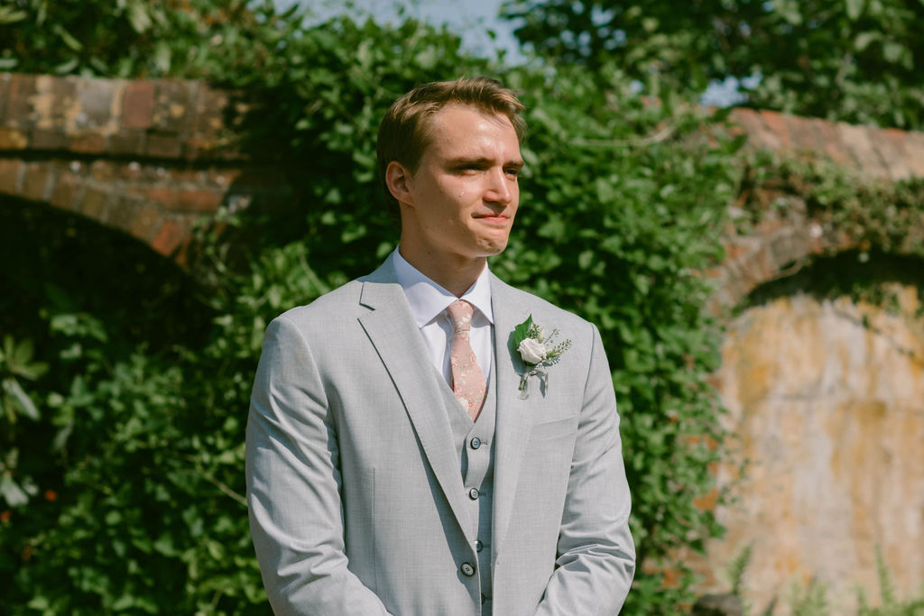 A Romantic Connecticut garden wedding first look down the aisle tear falling from groom's eye